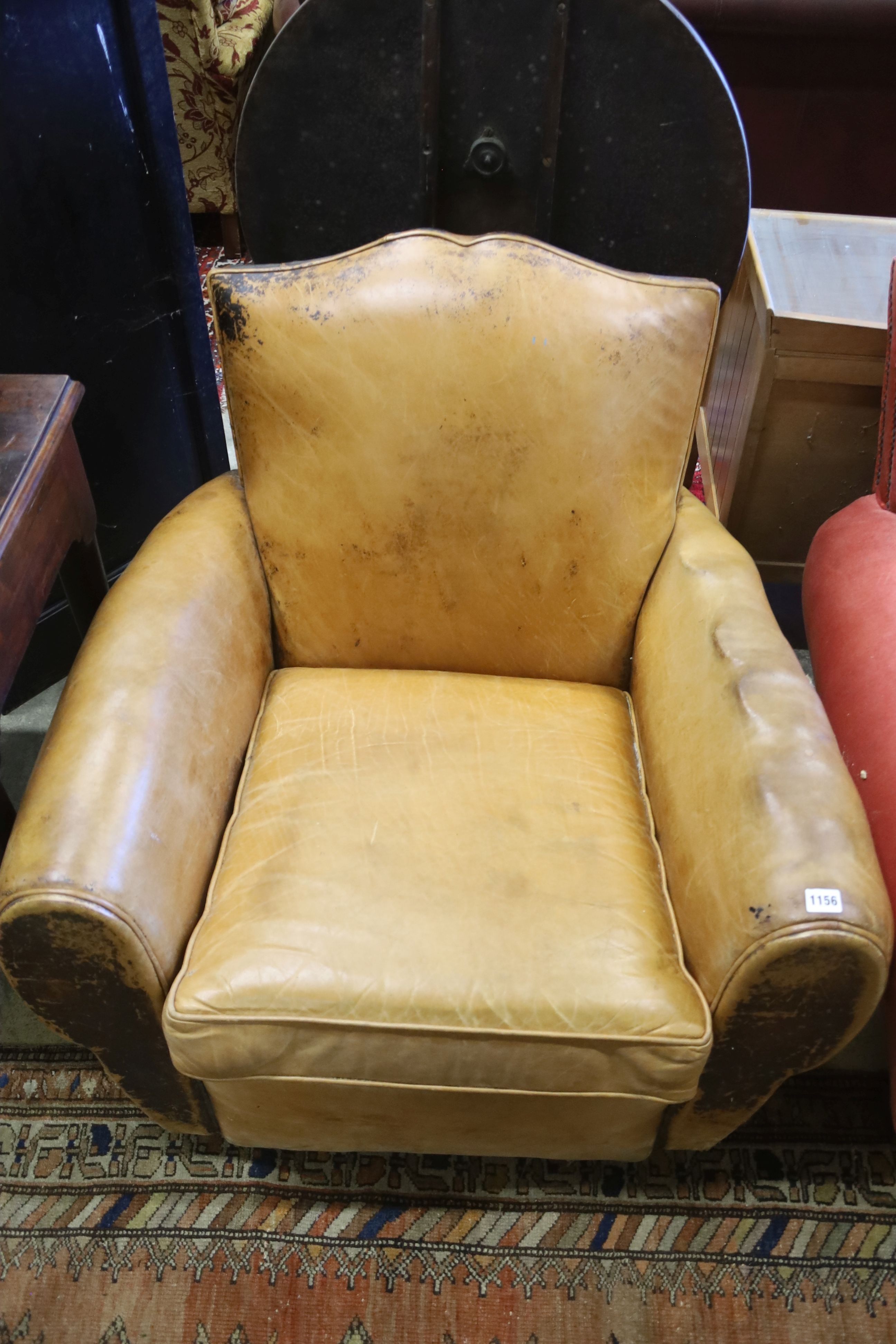 An early 20th century French tan leather armchair, width 86cm, depth 84cm, height 77cm